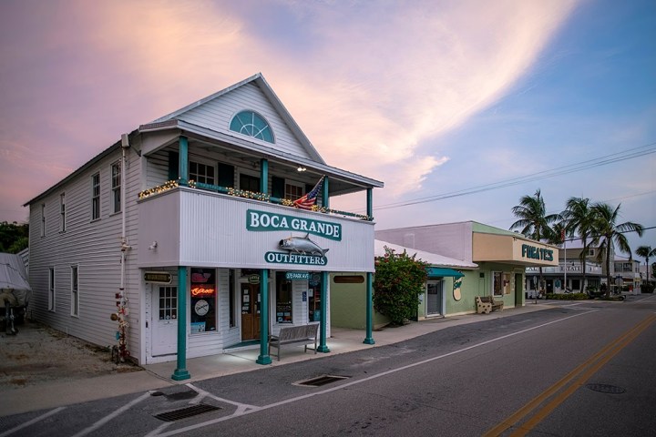 a house that has a sign on the side of a road