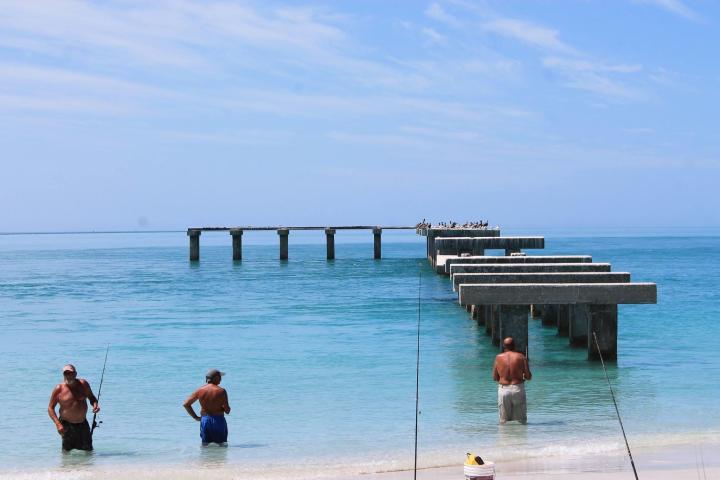 a group of people on a beach near a body of water