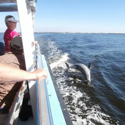 a man holding a fish on a boat in the water
